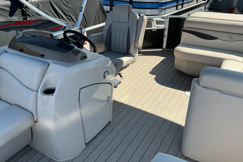 Slide: The Image of 2018 Bennington SX 21 SLXP pontoon boat interior with plush seating and steering console. - 12