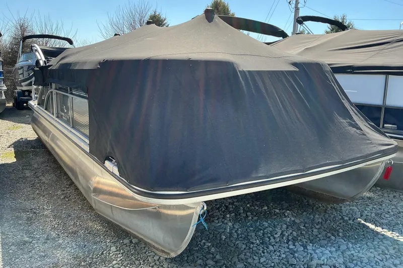Slide: The Image of 2018 Bennington SX 21 SLXP pontoon boat with cover, parked on gravel. - 18