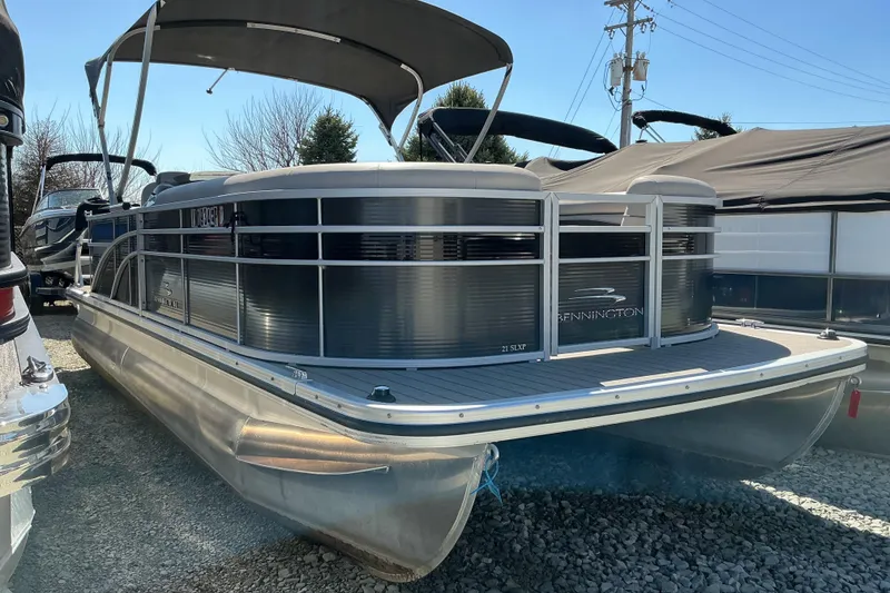 Slide: The Image of 2018 Bennington SX 21 SLXP pontoon boat with canopy, parked on gravel. - 3