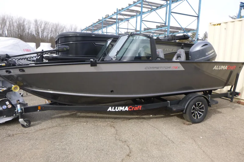 The Image of 2025 Alumacraft Competitor 175X Sport boat on trailer, parked outdoors. - 1