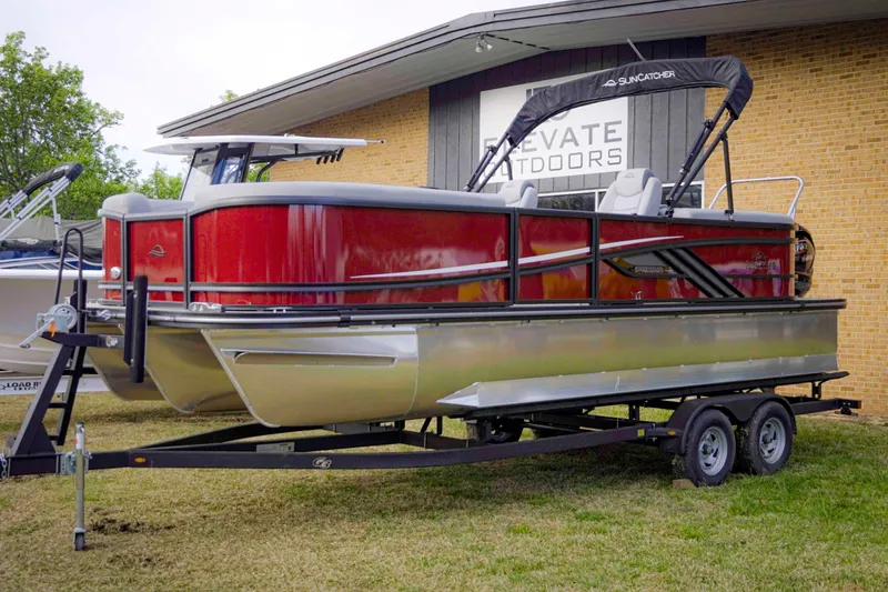 The Image of 2025 SunCatcher Fusion 322RC pontoon boat on trailer, displayed outdoors. - 1