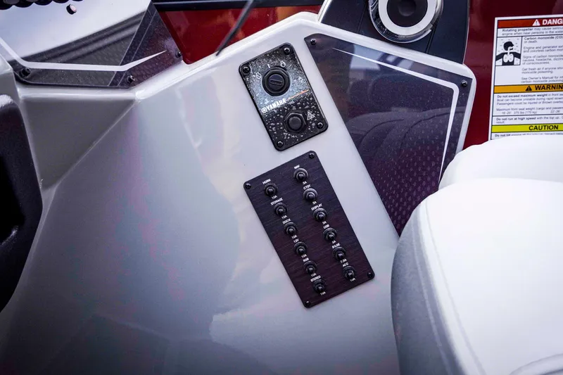Slide: The Image of Control panel of 2025 SunCatcher Fusion 322RC boat with switches and warning labels. - 24