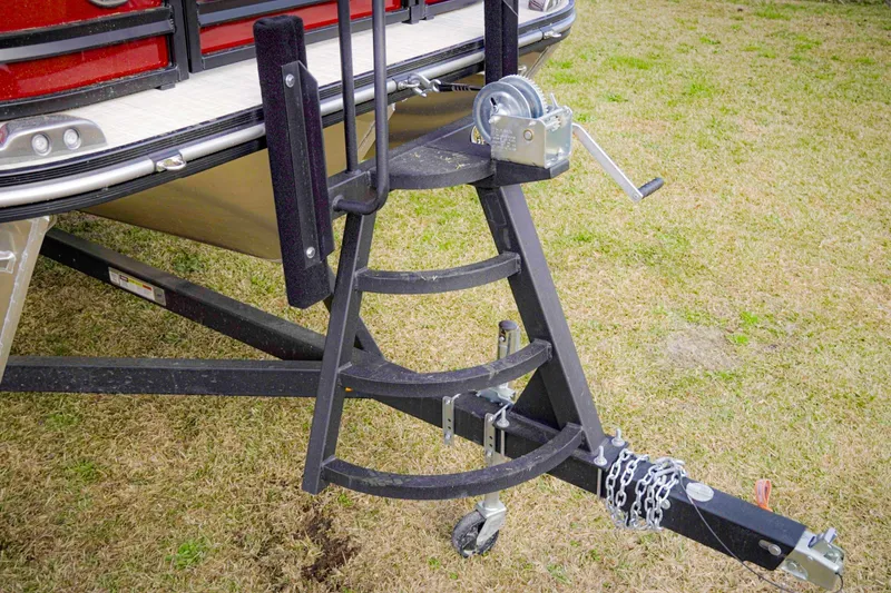 Slide: The Image of Trailer hitch and winch of 2025 SunCatcher Fusion 322RC boat on grass. - 3