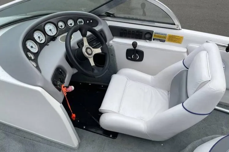 Slide: The Image of 2001 Supra Legacy boat interior with steering wheel and white captain's chair. - 4