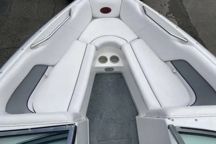 Slide: The Image of 2001 Supra Legacy boat interior with white cushioned seating and cup holders. - 8