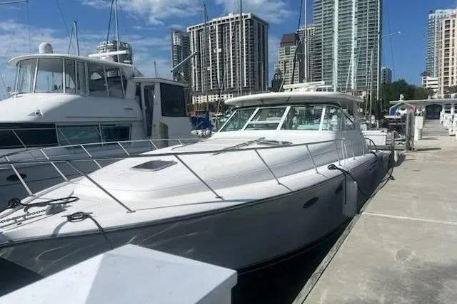 The Image of 2002 Tiara Yachts 4300 Open docked in a marina with city skyline. - 0
