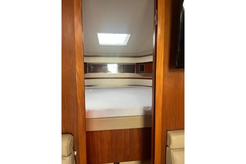 Slide: The Image of Interior cabin view of 2002 Tiara Yachts 4300 Open, featuring a cozy bed and wooden finish. - 10