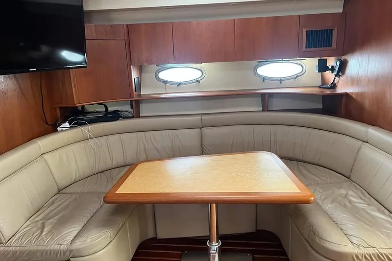 Slide: The Image of Interior of 2002 Tiara Yachts 4300 Open with leather seating and wooden table. - 13