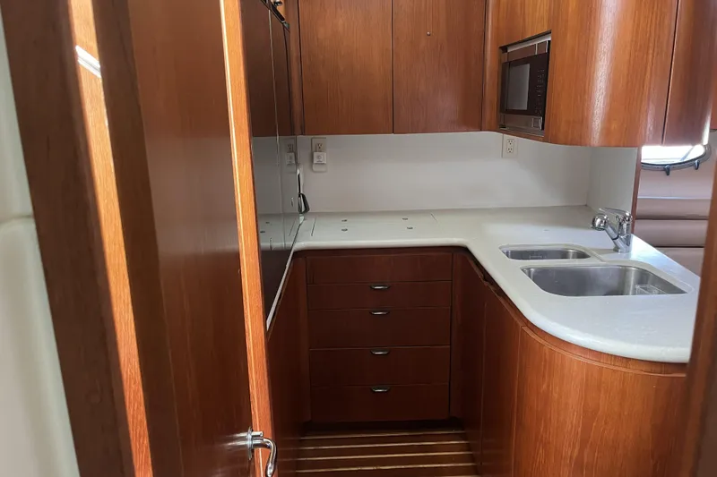 Slide: The Image of Luxurious 2002 Tiara Yachts 4300 Open kitchen with wood cabinetry and modern appliances. - 16