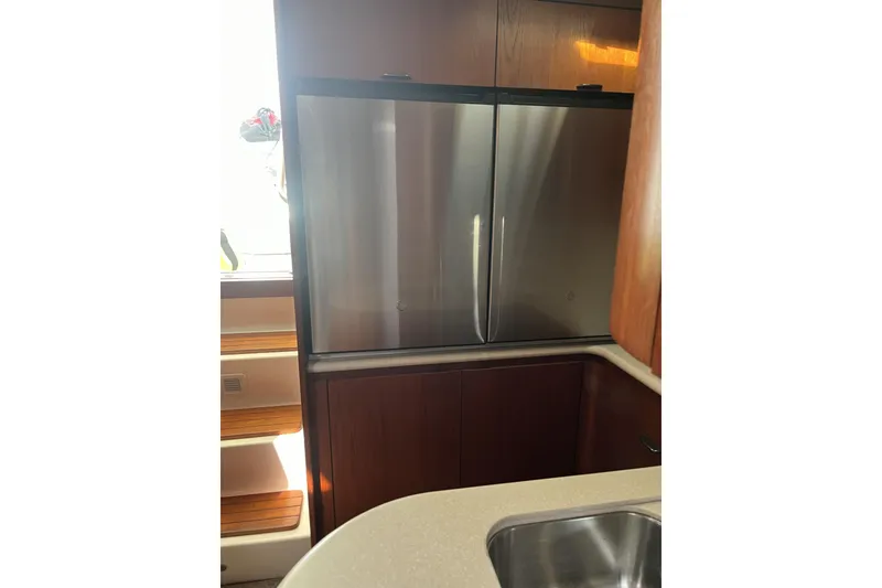Slide: The Image of Kitchen area of a 2002 Tiara Yachts 4300 Open, featuring a stainless steel refrigerator. - 17
