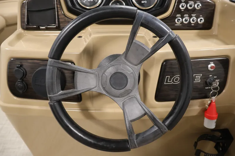 Slide: The Image of Steering wheel of 2021 Lowe SS 230 WT boat with dashboard controls. - 21