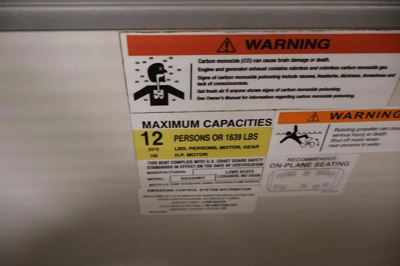 Slide: The Image of Warning label on 2021 Lowe SS 230 WT boat, showing maximum capacity and safety instructions. - 27