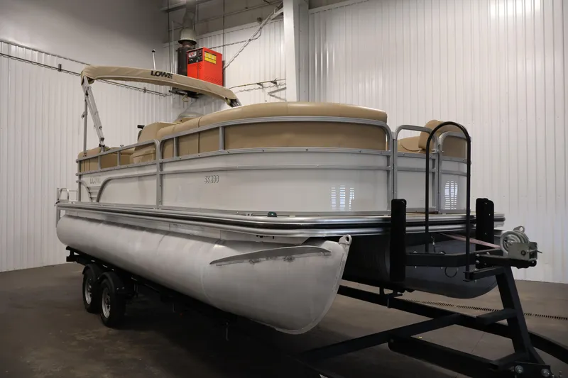 Slide: The Image of 2021 Lowe SS 230 WT pontoon boat on trailer in indoor storage. - 3