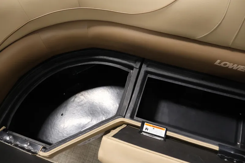 Slide: The Image of Interior storage compartments of a 2021 Lowe SS 230 WT boat, featuring cushioned seating. - 33