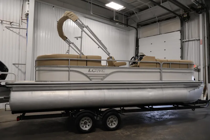 Slide: The Image of 2021 Lowe SS 230 WT pontoon boat on trailer in indoor storage. - 4