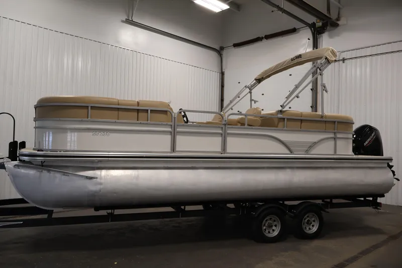 Slide: The Image of 2021 Lowe SS 230 WT pontoon boat in indoor storage, side view. - 8
