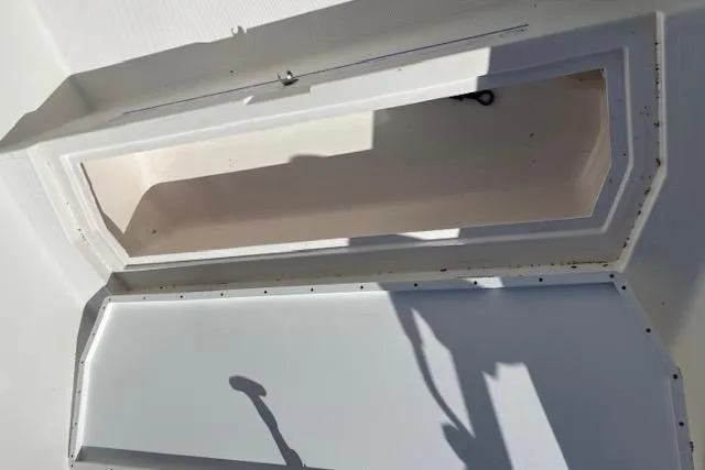 Slide: The Image of Open storage compartment on a 2006 Clearwater 2100 boat, showing interior space. - 12