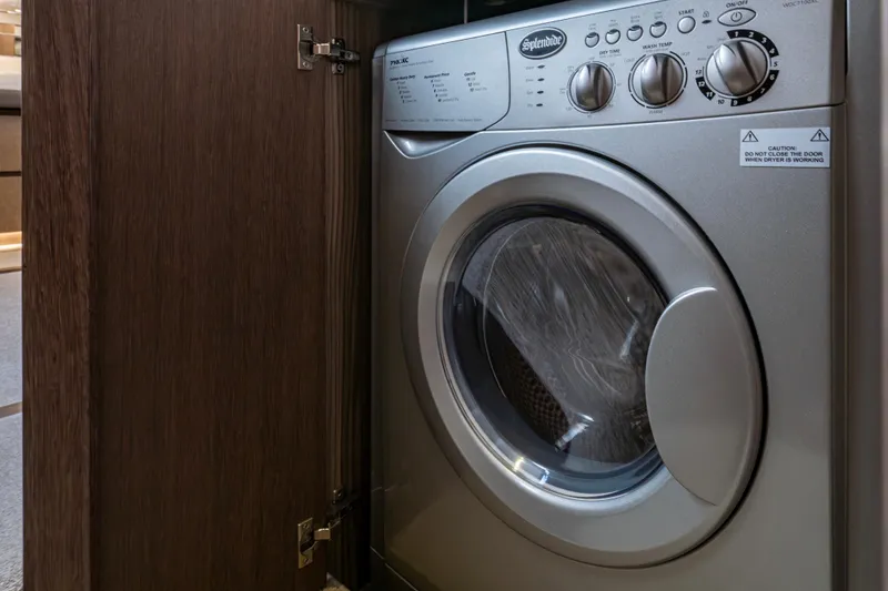 Slide: The Image of Washing machine inside Galeon 550 Fly yacht, 2020 model, with wooden cabinet door open. - 25