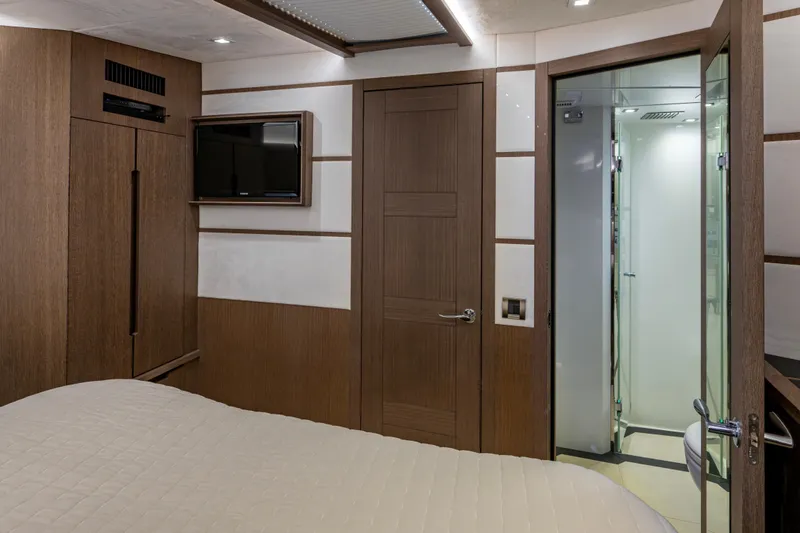 Slide: The Image of Interior of 2020 Galeon 550 Fly yacht cabin with modern wood paneling and ensuite bathroom. - 37