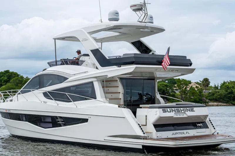 Slide: The Image of 2020 Galeon 550 Fly yacht cruising on water, featuring sleek design and American flag. - 49