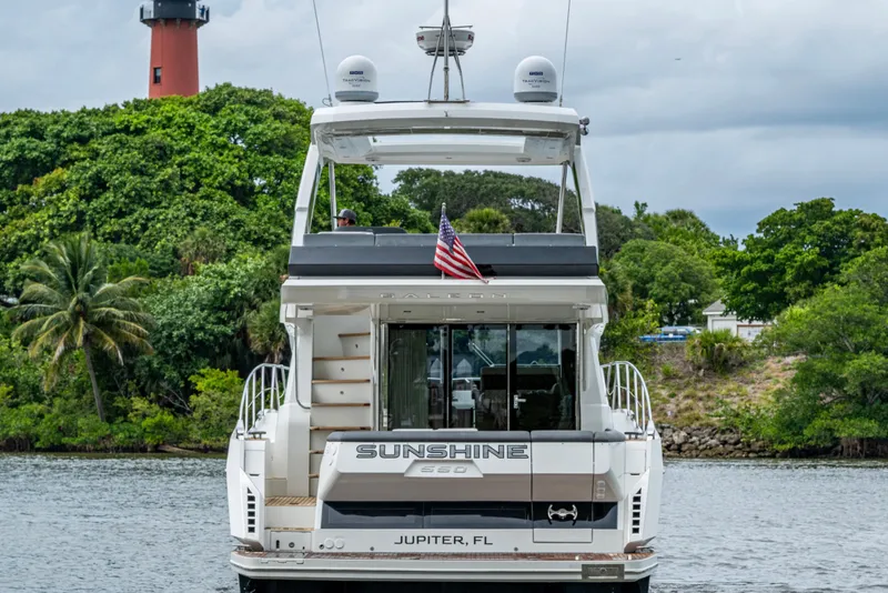 Slide: The Image of 2020 Galeon 550 Fly yacht on water, lush greenery, lighthouse in background. - 50