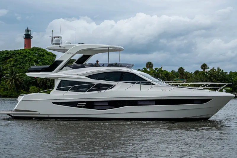 Slide: The Image of 2020 Galeon 550 Fly yacht cruising near a lighthouse and lush greenery. - 53