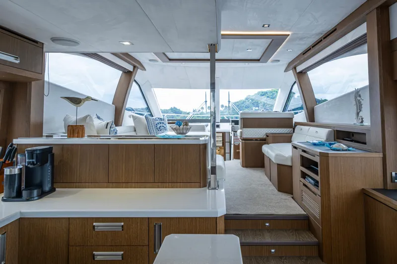 Slide: The Image of Luxurious interior of 2020 Galeon 550 Fly yacht with modern wood finishes and seating. - 9