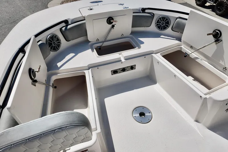 Slide: The Image of 2026 Carolina Skiff 21 Ultra Elite boat interior with open storage compartments and speakers. - 10