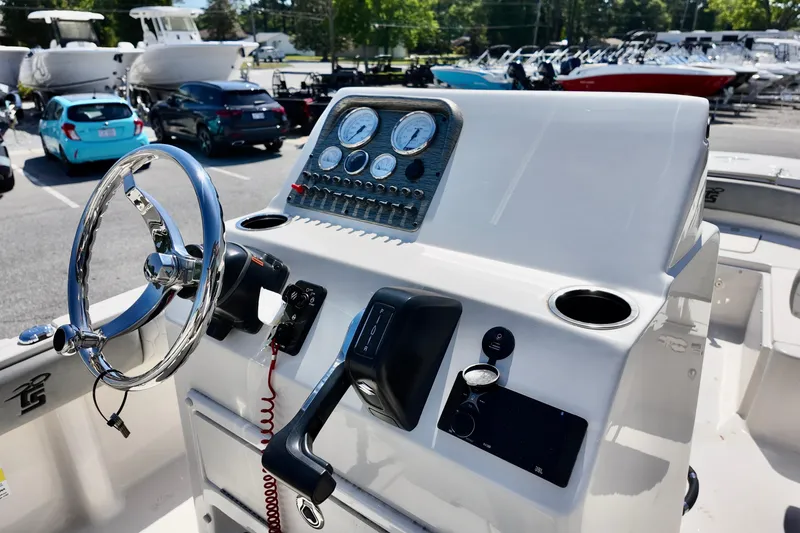 Slide: The Image of Steering console of 2026 Carolina Skiff 21 Ultra Elite boat in a marina setting. - 7