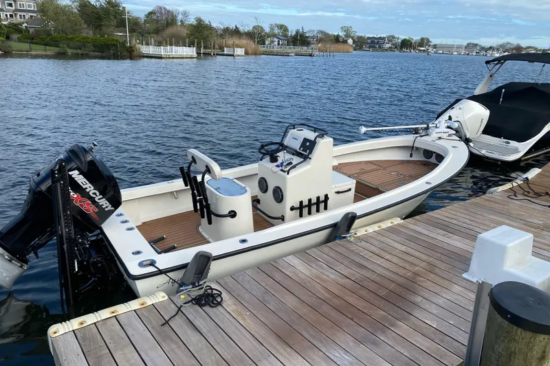 Slide: The Image of 1973 Aquasport 190 Osprey boat docked on a serene waterfront with Mercury engine. - 5