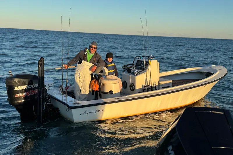 Slide: The Image of 1973 Aquasport 190 Osprey boat with two people fishing on open water. - 7