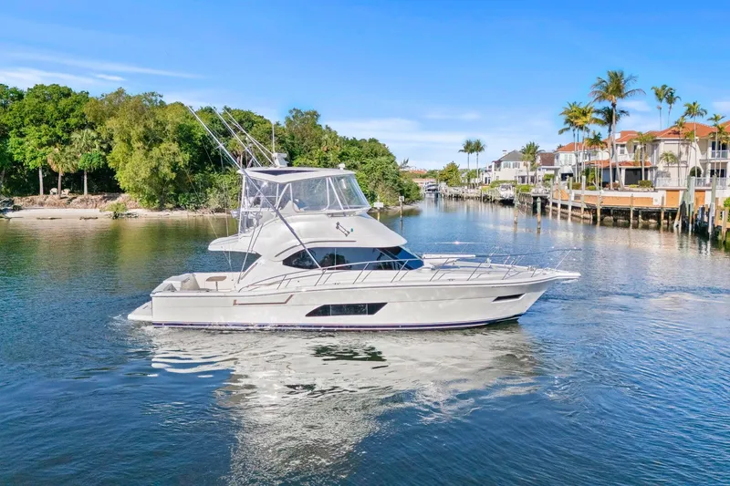 The Image of 2016 Riviera 43 Open Flybridge yacht cruising in a scenic waterfront setting. - 1