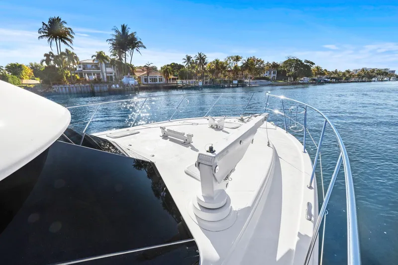 Slide: The Image of 2016 Riviera 43 Open Flybridge yacht cruising near waterfront homes. - 15