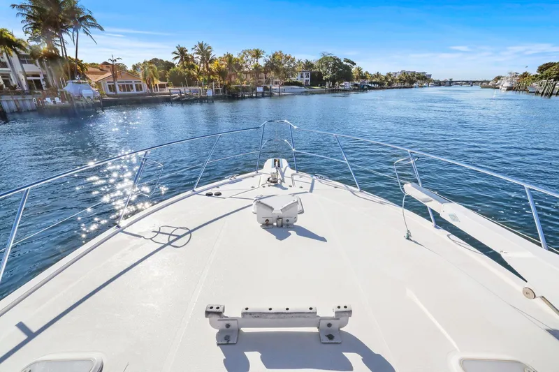 Slide: The Image of 2016 Riviera 43 Open Flybridge cruising on a sunny waterway with palm trees. - 17