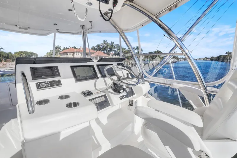 Slide: The Image of 2016 Riviera 43 Open Flybridge helm with modern controls and scenic waterway view. - 20