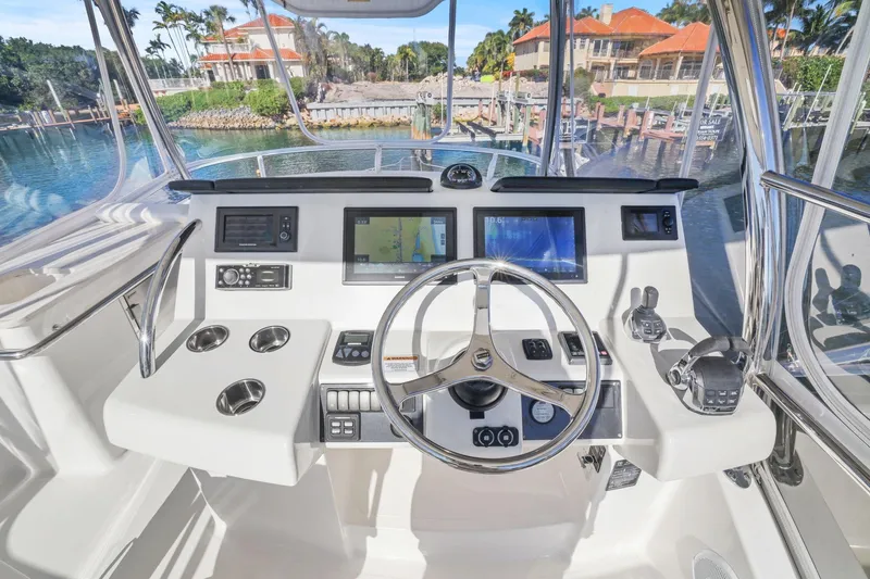 Slide: The Image of Helm of 2016 Riviera 43 Open Flybridge with modern navigation equipment and scenic marina view. - 22