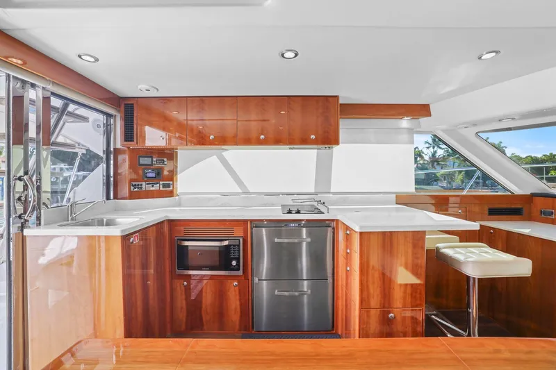 Slide: The Image of Luxurious 2016 Riviera 43 Open Flybridge yacht kitchen with modern appliances and sleek wood cabinetry. - 32