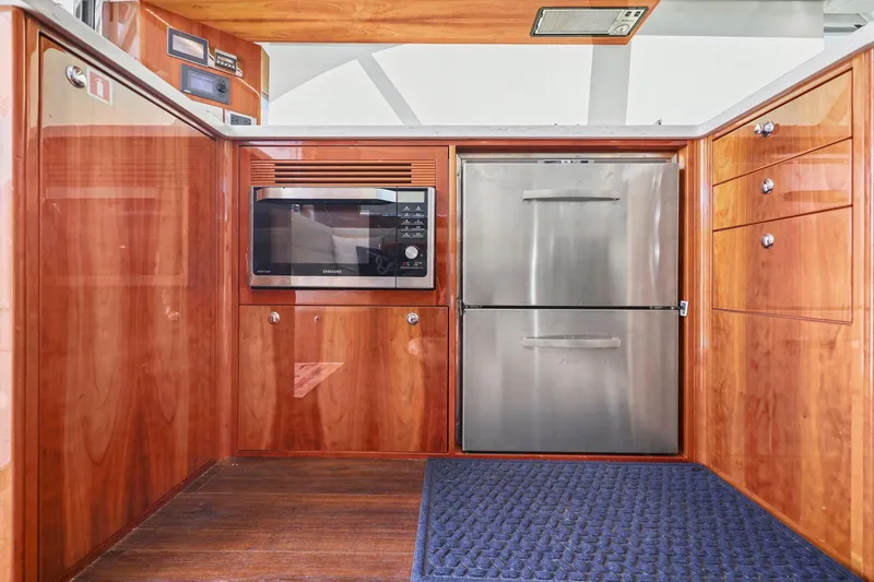 Slide: The Image of Luxurious 2016 Riviera 43 Open Flybridge yacht kitchen with wood cabinetry and stainless steel appliances. - 34