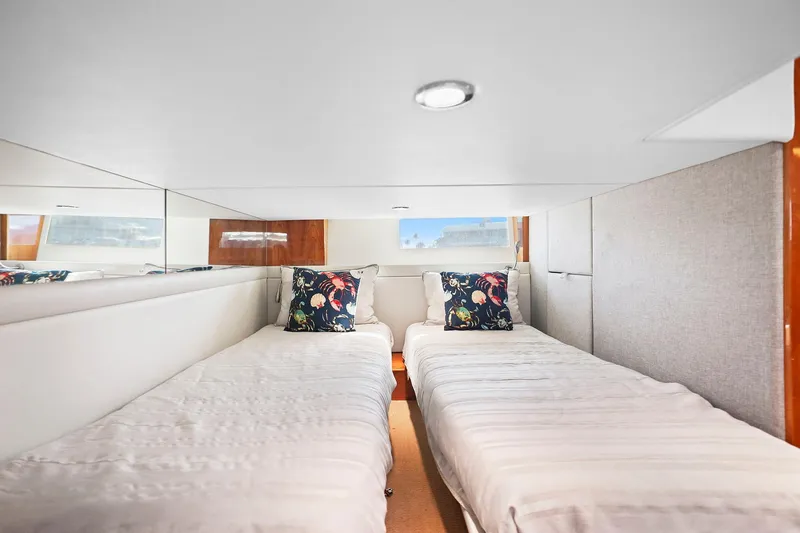 Slide: The Image of Interior of 2016 Riviera 43 Open Flybridge with twin beds and decorative pillows. - 43
