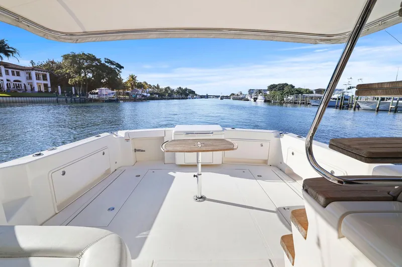 Slide: The Image of 2016 Riviera 43 Open Flybridge yacht deck with scenic waterfront view. - 52