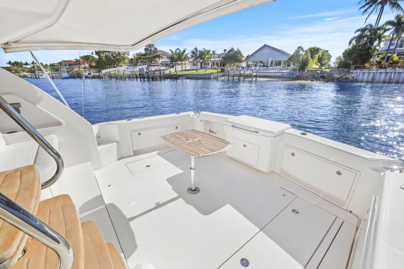 Slide: The Image of 2016 Riviera 43 Open Flybridge yacht deck with scenic waterfront view. - 53