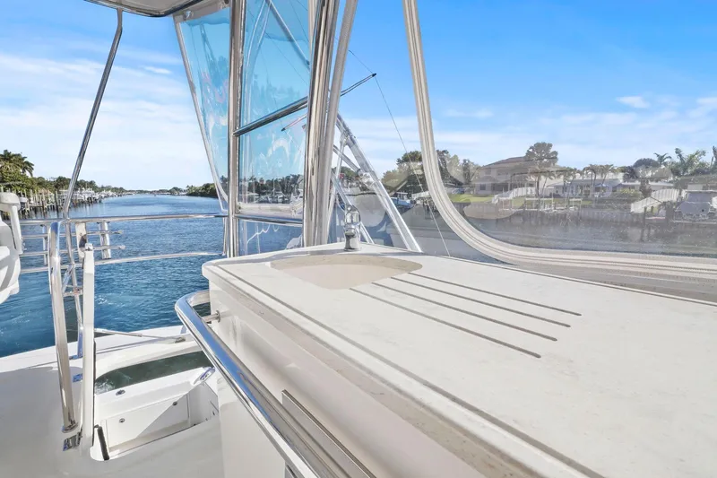 Slide: The Image of Flybridge view from 2016 Riviera 43 Open, overlooking serene waterfront and clear blue skies. - 54