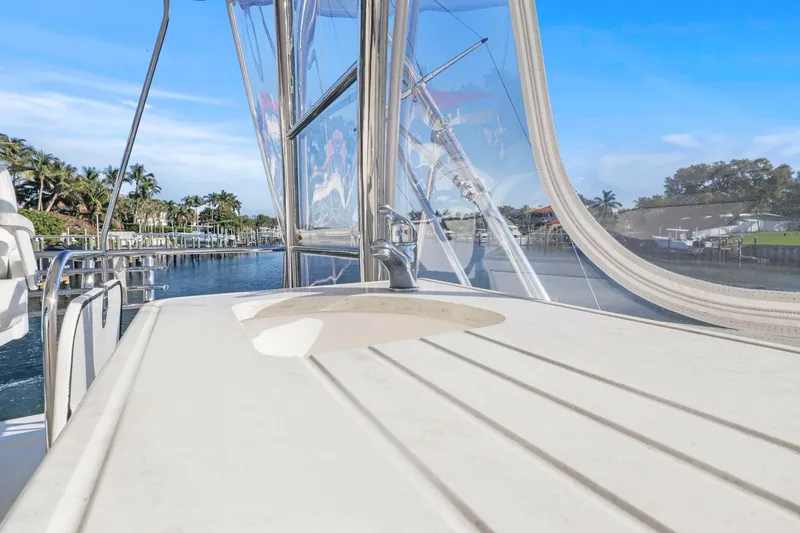 Slide: The Image of 2016 Riviera 43 Open Flybridge yacht with sink, overlooking serene waterfront and palm trees. - 55