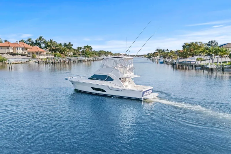 Slide: The Image of 2016 Riviera 43 Open Flybridge yacht cruising in a scenic waterfront setting. - 6