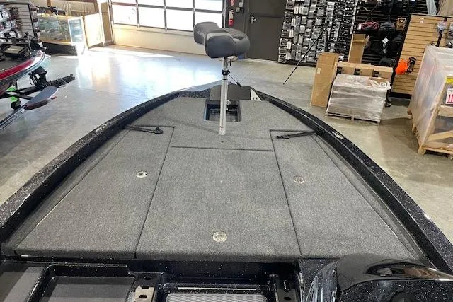 Slide: The Image of 2027 Caymas 201 Pro boat interior with gray carpet and seating in a showroom. - 11