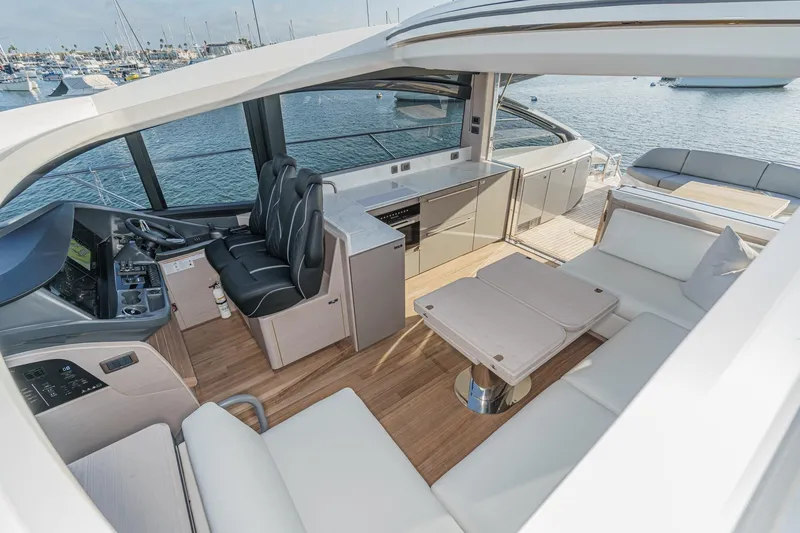 Slide: The Image of Luxurious 2026 Princess V55 yacht interior with modern seating and helm, overlooking serene waters. - 17