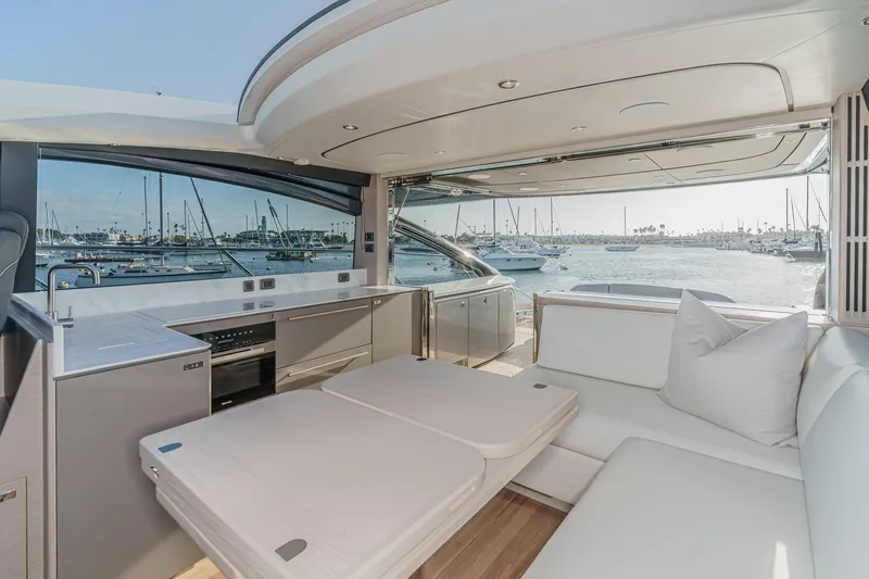 Slide: The Image of Luxurious 2026 Princess V55 yacht interior with marina view, featuring modern seating and kitchen area. - 22
