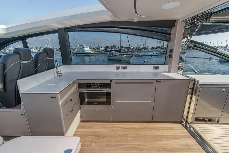 Slide: The Image of Luxurious interior of 2026 Princess V55 yacht with modern kitchen and scenic marina view. - 30