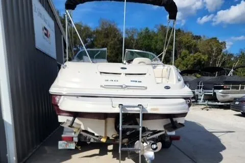Slide: The Image of 2008 Sea Ray 240 Sundeck boat, rear view, parked outdoors under blue sky. - 11