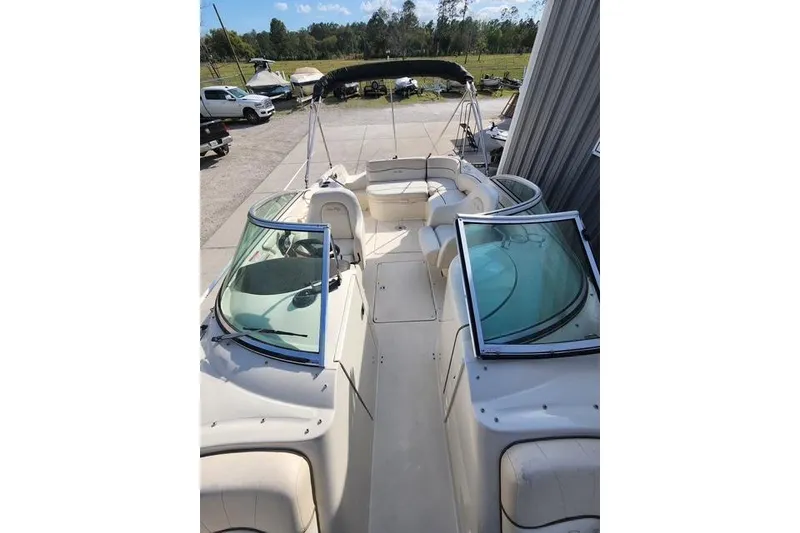 Slide: The Image of 2008 Sea Ray 240 Sundeck boat with spacious seating and windshield, parked outdoors. - 8